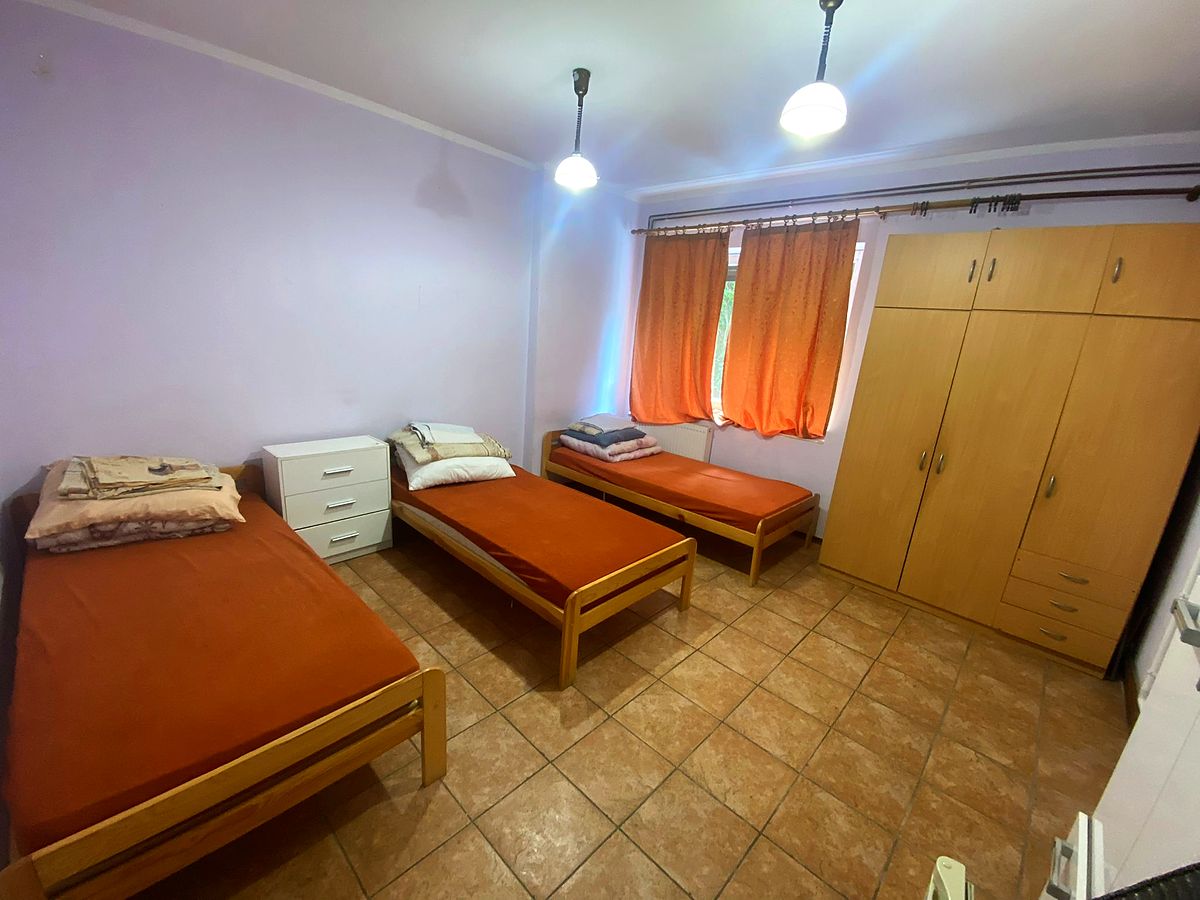 Pokój z trzema pojedynczymi łóżkami i komodą
